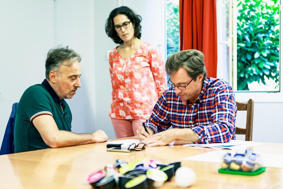 2 hommes et 1 femme discute à table